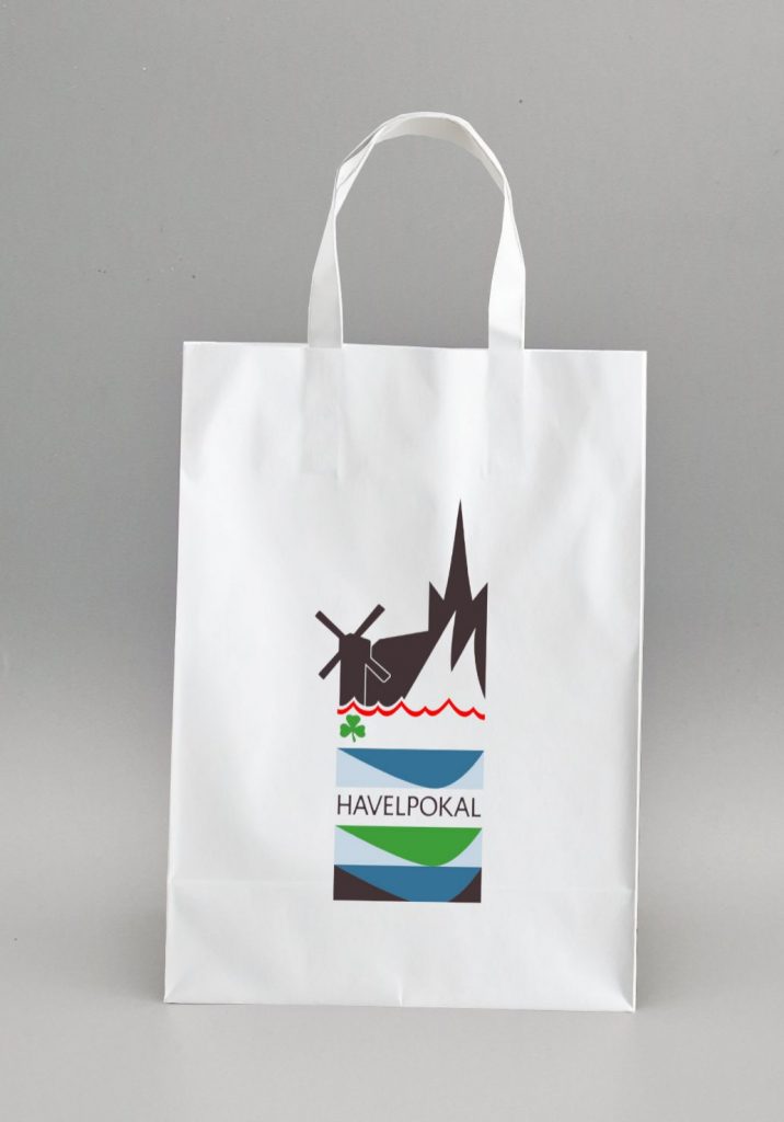 weiße Goodie-Bag aus Papier, bedruckt mit Grafik Design aus dem Sportevent-Branding von Silja Wolff mit grafischen Flächen und Event-Logo oben in der Mitte