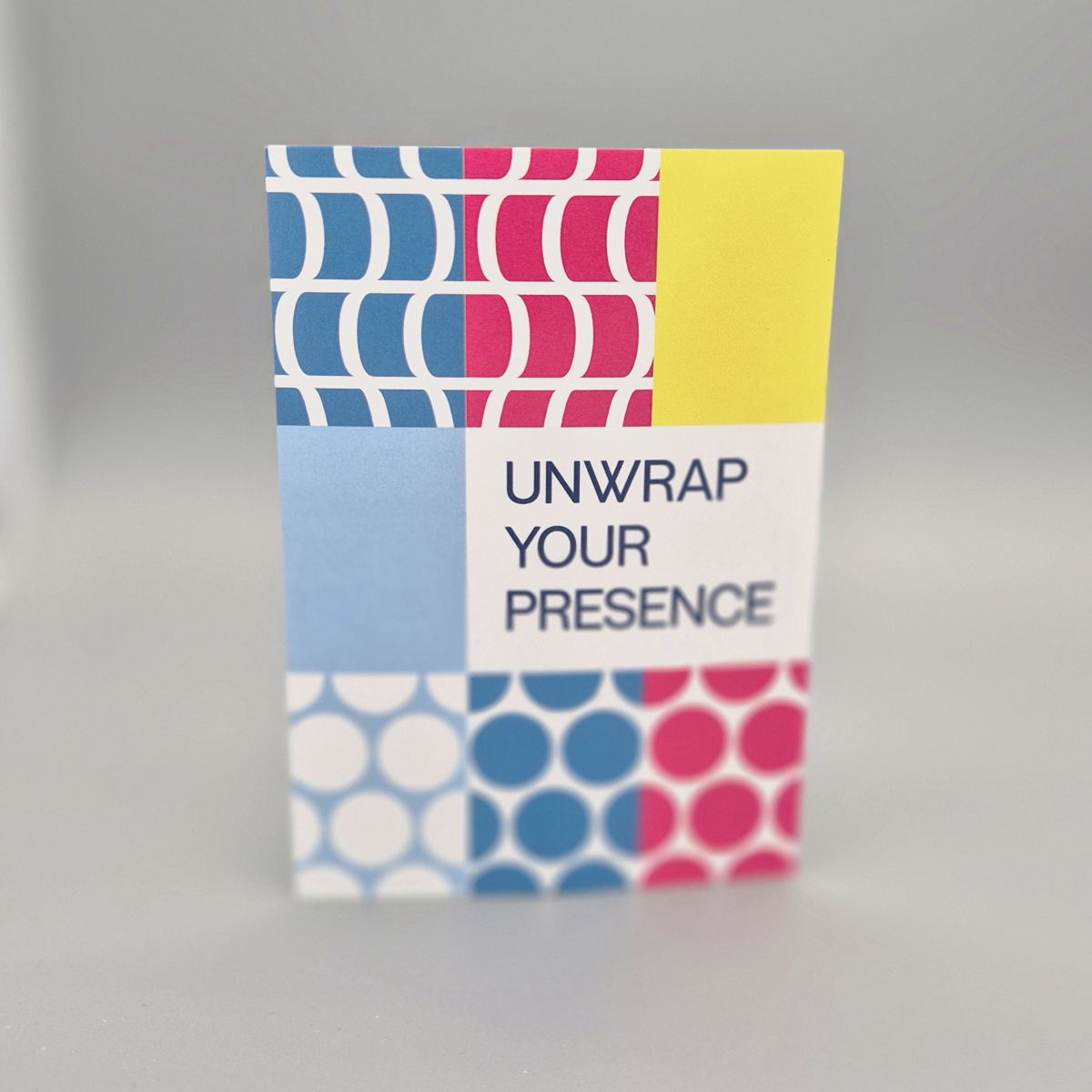 Brand Design umgesetzt als farbstarke Akzente und Muster im Rasterlayout auf einer postkarte, ergänzt von dem Text unwrap your presence